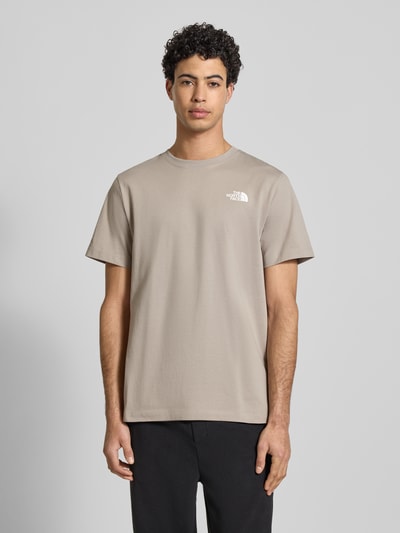Männermodel trägt Regular Fit T-Shirt aus Baumwoll-Mix Modell 'EVOLUTION' von The North Face in Beige mit Label-Detail, Ganzkörperansicht von vorne. Herren T-Shirt, Rundhalsausschnitt, Rückenlänge bei Größe M: 70 cm.