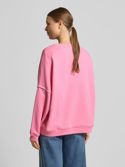 Modelka kobieca nosi Oversized Sweatshirt mit Motiv-Print od miss goodlife, różowa bawełna, ściągacze, dekolt okrągły, tył, widok całej sylwetki