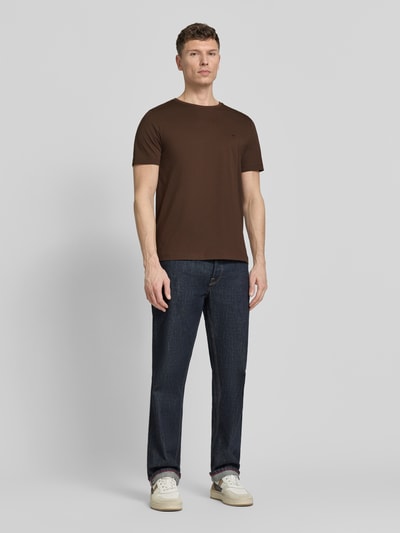 Männermodel trägt T-Shirt mit Rundhalsausschnitt und Label-Stitching von Fynch-Hatton, Reine Baumwolle, Regular-Fit, Ganzkörperansicht von vorne.