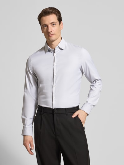 Männermodel trägt Slim Fit Business-Hemd mit Kentkragen von Jake*s in hellgrau, Material-Mix mit Stretch-Anteil, Ganzkörperansicht von vorne.