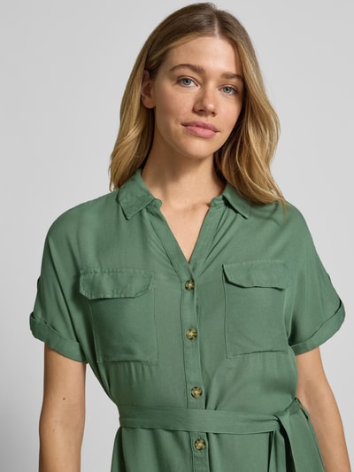 Frauenmodel trägt fließendes Freizeitkleid aus reiner Viskose Modell 'BUMPY' von Vero Moda in Uni-Optik, grün, Popeline, Nahaufnahme Oberkörper.
