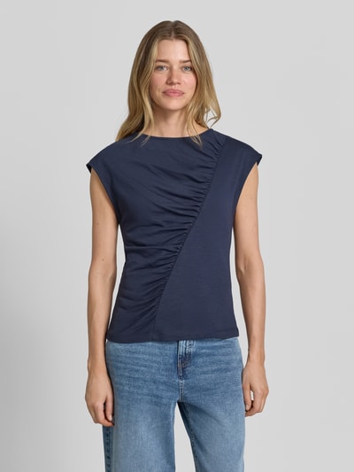Vrouwenmodel draagt T-shirt met ronde hals en draperingen van Christian Berg Woman, mix van katoen en micromodal, slim fit, kapmouwen, ruglengte maat S 56 cm. Ganzkörperansicht von voren.