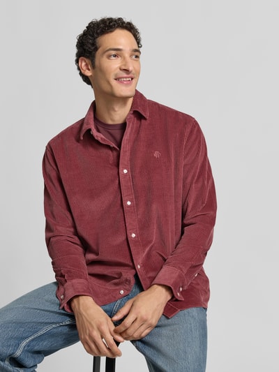 Männermodel trägt Regular Fit Freizeithemd mit Label-Stitching von MCNEAL in Rot aus Cord mit Kentkragen, Ganzkörperansicht von vorne. Kontext: Herren Freizeithemd aus reiner Baumwolle, Rückenlänge 76 cm, Schulterbreite 42 cm, Ärmellänge 66 cm.