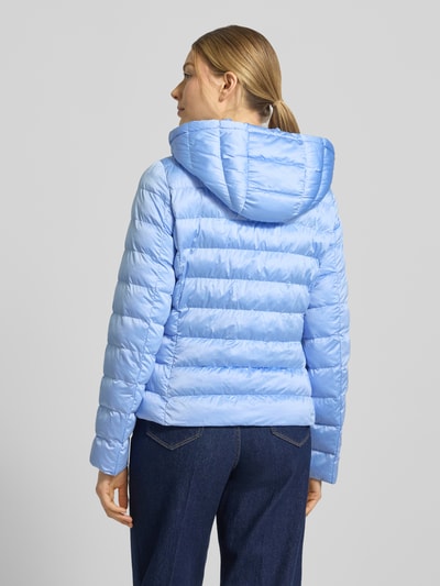 Frauenmodel trägt taillierte Steppjacke mit Zweiwege-Reißverschluss Modell 'ANYA' von Beaumont Amsterdam in Hellblau, Rückenansicht, Damen Steppjacke mit Kapuze und Tunnelzug, strukturierte Oberfläche, Detailinfos zu Maßen und Schnitt. Ganzkörperansicht Rückansicht.
