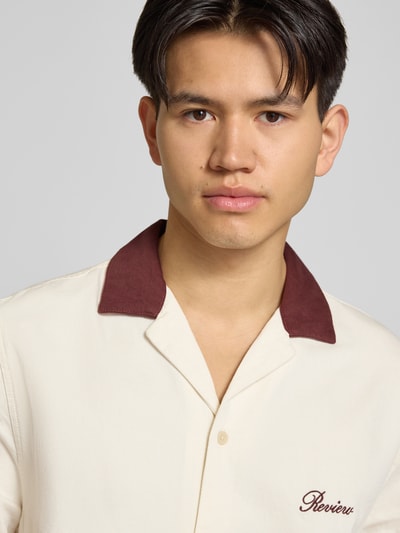 Männermodel trägt Regular Fit vrijetijdsoverhemd met contrastkraag van REVIEW, katoen- en viscosemix, gestikt logo, nahaufnahme bovenlichaam.