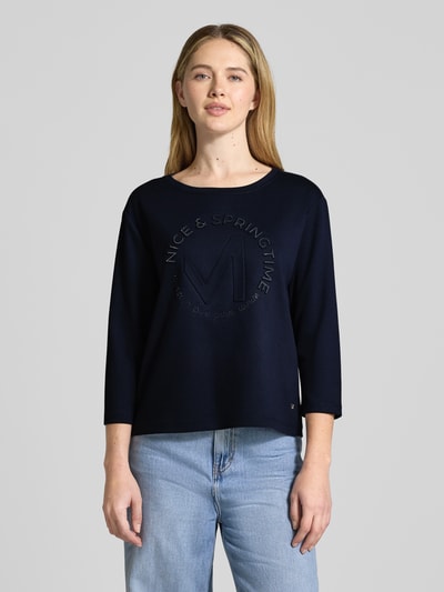 Vrouwenmodel draagt Relaxed Fit Sweatshirt met viscose-aandeel model 'Emblem' van monari, donkerblauw, ronde hals, 7/8-mouw, elastisch materiaal, vooraanzicht bovenlichaam