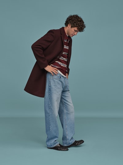 Männermodel trägt Baggy Jeans in heller Waschung und klassischem Five-Pocket-Design von REVIEW, reine Baumwolle, Ganzkörperansicht von vorne.