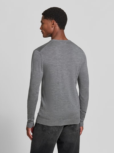 Męski model nosi sweter wełniany z prostym krojem Matinique Strickpullover mit gerippten Abschlüssen Modell 'Margrate', szary kolor, prążkowane wykończenia, okrągły dekolt, długość tyłu w rozmiarze M: 63 cm, długość rękawów w rozmiarze M: 69 cm, widok całej sylwetki z tyłu.