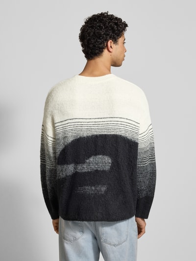 Mężczyznamodel nosi Oversized Strickpullover mit gerippten Abschlüssen von ANOTHER COTTON LAB, mieszanka materiałów z dodatkiem wełny, prążkowane wykończenia, okrągły dekolt, wyhaftowane logo, długość tyłu 68 cm, długość rękawów 55 cm, widok całej sylwetki z tyłu.