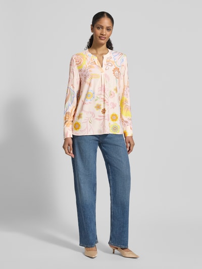 Vrouwenmodel draagt Regular Fit Bluse aus Seide-Elasthan-Mix van HERZENS, tuniekkraag, allover look, pastel en bloemmotief, frontale full-body opname.