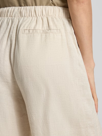 Frauenmodel trägt Leinenhose mit elastischem Bund Modell 'FLORA' von Stefanel, cremefarben, strukturierte Oberfläche, Detailaufnahme Rückansicht, reine Leinenqualität, angedeutete Gesäßleistentasche, Wide Leg Fit.