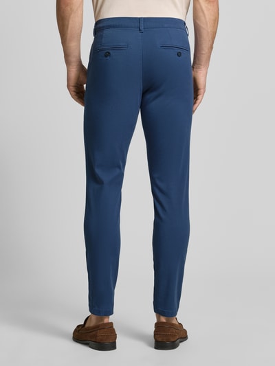 Männermodel trägt blauwe slim fit chino van katoenmix model 'GABARDINE' van Selected Homme, Heren chino, ganzlichaamsaanzicht achteraan.