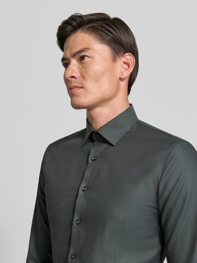 Männermodel trägt Super Slim Fit Businesshemd aus Baumwoll-Mix von OLYMP No. Six in dunklem Grau mit feiner Struktur, Nahaufnahme Oberkörper.