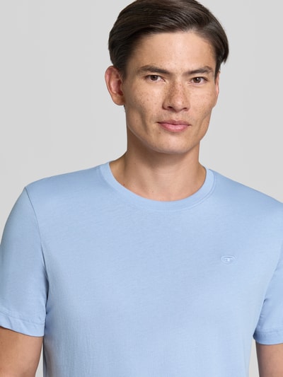 Männermodel trägt Regular Fit T-Shirt aus reiner Baumwolle von Tom Tailor in Hellblau, glatte Struktur, Nahaufnahme Oberkörper, Herren T-Shirt von Tom Tailor.