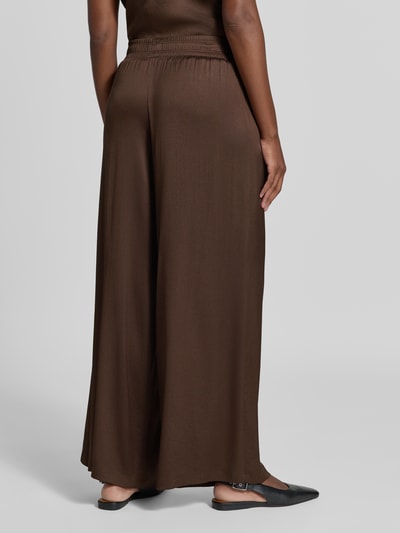 Frauenmodel trägt Hose mit elastischem Bund Modell 'CEILING' von DRYKORN, braun, Wide Leg, Material-Mix, Ganzkörperansicht Rückansicht.