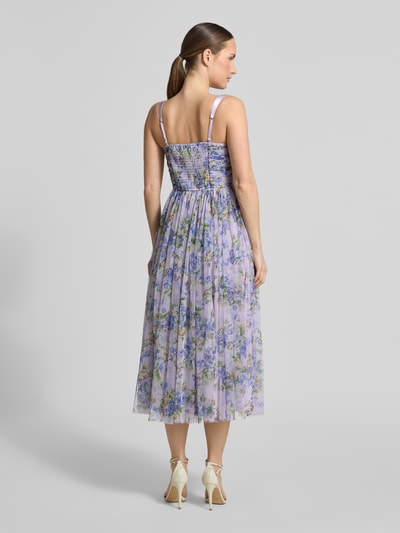 Frauenmodel trägt Cocktailkleid aus Tüll im Allover-Look von LACE & BEADS in zarten Lilatönen mit floralen Mustern, A-Linie, Midikleid, Corsagenkleid, Rückenlänge 125 cm, Brustweite 34 cm, Ganzkörperansicht Rückansicht.