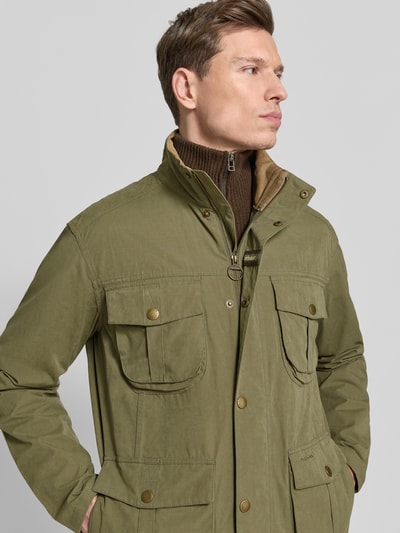 Männermodel trägt Regular Fit Jacke aus Baumwoll-Mix Modell 'SANDERLING' von Barbour in Oliv, Optik: Unifarben, Nahaufnahme Oberkörper.