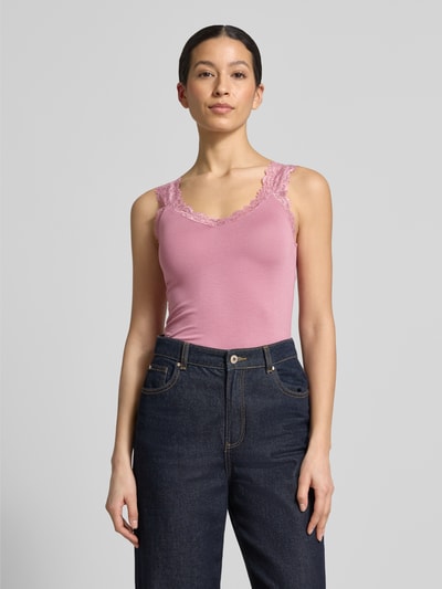Frauenmodel trägt Slim Fit Tank Top aus Viskose-Mix Modell 'ROSA' von Vero Moda in Optik: Unifarben mit Spitzenbesatz, V-Ausschnitt, breite Träger, Material mit glatter Textur, Ganzkörperansicht von vorne.