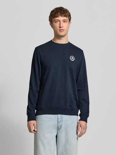 Männermodel trägt Regular Fit Pullover mit Logo-Stitching Modell 'Kane' von Blend, katoenmix, ronde hals, elastische boorden, donkerblauw; Ganzkörperansicht von vorne