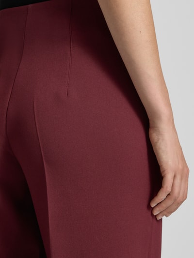 Frauenmodel trägt Stoffhose mit Bügelfalte und Eingrifftaschen von MORE & MORE, Bordeauxrot, Material-Mix, Nahaufnahme Hüfte