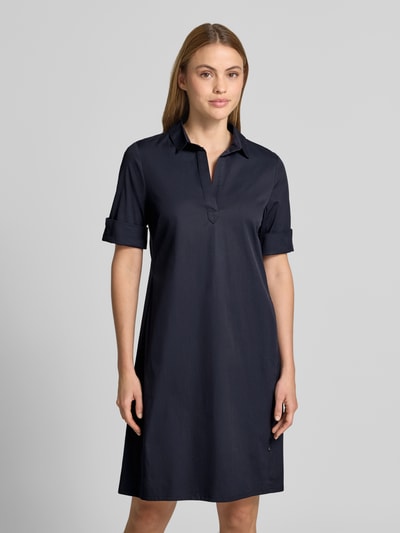 Frauenmodel trägt Hemdblusenkleid mit V-Ausschnitt von ROBE LÉGÈRE aus dunkelblauem Baumwoll-Mix, Gerader-Schnitt, Minikleid, Hemdblusenkragen, Aufschlag an den Ärmeln, Ganzkörperansicht von vorne. Rückenlänge bei Größe 36: 86 cm, Brustweite: 37 cm, Ärmellänge: 26 cm.