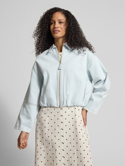 Vrouwenmodel draagt Jeansjacke mit Reißverschluss van Jake*s Casual, lichtblauw, relaxed fit, zuivere katoen, schouderbreedte 54 cm, borstwijdte 57 cm, lengte 53 cm, mouwlengte 48 cm, kleur- en stofdetails duidelijk zichtbaar, volledige vooraanzicht van het bovenlichaam.