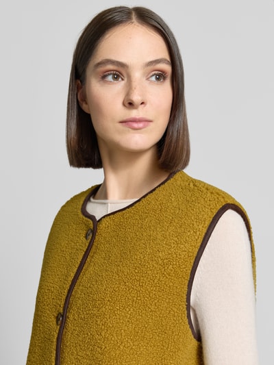 Vrouwenmodel draagt Relaxed Fit bodywarmer met doorlopende knoopsluiting van Christian Berg Woman, teddybont, ronde hals, mouwloos, zij-steekzakken, detailopname bovenlichaam.