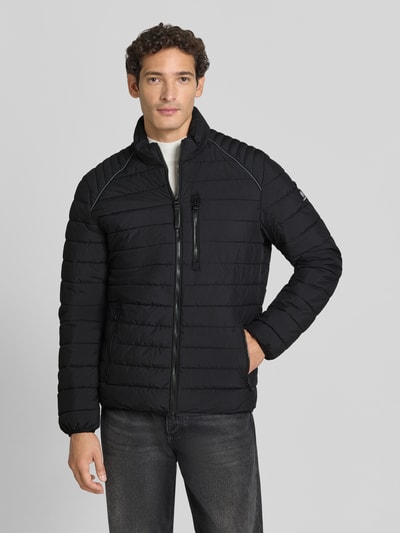 Männermodel trägt schwarze Steppjacke mit Stehkragen und Reißverschlusstaschen von LERROS, Regular Fit, Ganzkörperansicht von vorne.