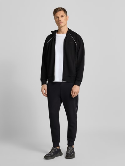 Männermodel trägt Regular Fit Sweat-Anzug aus Baumwoll-Mix Modell 'TRACKSUIT SET' van BOSS Green in zwart, unifarben, Ganzkörperansicht von vorne.