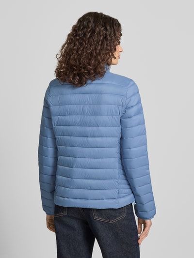 Modelka kobieca nosi Steppjacke mit Logo-Stitching Modell 'FUJI' od Superdry, jasnoniebieska, proste pikowanie, z widocznym logo, widok całej sylwetki z tyłu.