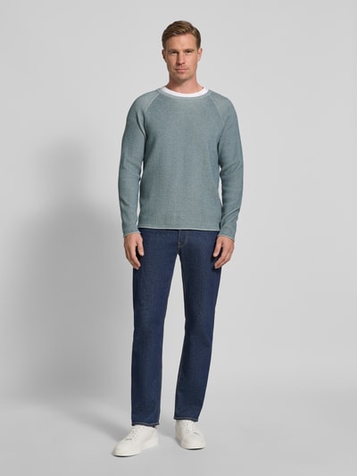 Männermodel trägt Strickpullover mit Rundhalsausschnitt Modell 'TITZIAN' von Drykorn aus Baumwoll-Mix, Regular Fit, Ganzkörperansicht von vorne.