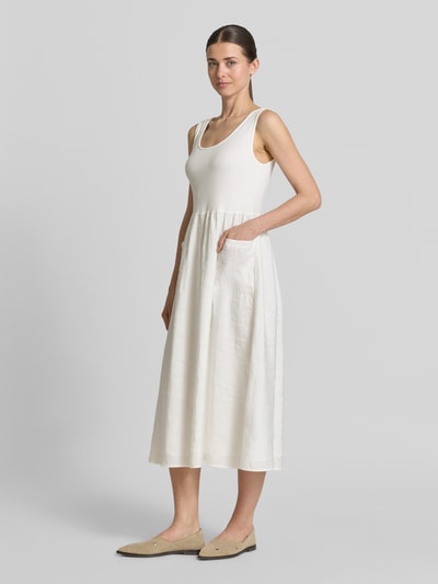 Frauenmodel trägt Midikleid mit aufgesetzten Taschen von Rich & Royal im Micromodal-Mix, Taillierte Passform, Rundhalsausschnitt, Ärmelloses-Design, weiß, glatte Textur, Ganzkörperansicht von vorne. Rückenlänge bei Größe S: 114 cm, Brustweite bei Größe S: 32 cm.
