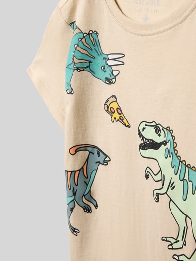 Mädchen trägt Regular Fit T-Shirt mit Allover-Motiv-Print von Blue Seven aus reiner Baumwolle, Rundhalsausschnitt, Nahaufnahme Oberkörper.