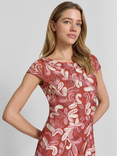 Vrouwenmodel draagt knielang 'Knielanges Cocktailkleid mit Applikationen' van Christian Berg Cocktail, materiaalmix met stretch, nauwsluitend model, ronde hals, florale applicaties in roze en crèmetinten, ruglengte maat 36: 89 cm, borstwijdte: 45 cm, mouwlengte: 11 cm, detailopname bovenlichaam.