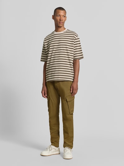 Männermodel trägt Straight Fit Cargohose aus Baumwoll-Mix von MCNEAL in Oliv mit Cargotaschen, Ganzkörperansicht von vorne, elastischer Material-Mix