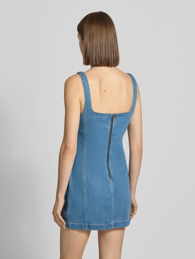 Modelka nosi 'Jeanskleid mit Logo-Stitching und Karree-Ausschnitt' von Guess Jeans, mieszanka lyocellu z dodatkiem wiskozy, krój slim fit, sukienka mini, prostokątny dekolt, wyhaftowane logo, zamek błyskawiczny z tyłu, długość tyłu w rozmiarze S 62 cm, szerokość w rozmiarze S 42 cm, stylizowana na denim, odcień jasnoniebieski, gładka faktura, widoczny szew, sukienka o dopasowanym kroju, widoczne detale na plecach, całkowity widok z tyłu