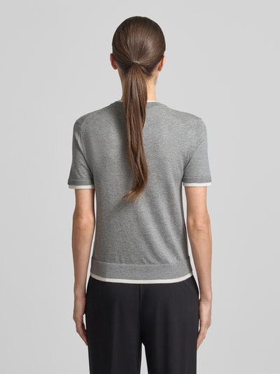 Modelka nosi Strickshirt aus Leinen-Mix in Two-Tone-Machart von Stefanel, szary z białymi krawędziami, krój slim fit, okrągły dekolt, mieszanka lnu z domieszką kaszmiru, długość tyłu w rozmiarze S 54 cm, długość rękawów 20 cm, dwukolorowy, widok całej sylwetki z tyłu.