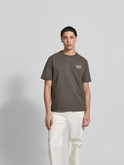 Männermodel trägt Regular Fit T-Shirt aus reiner Baumwolle von MAISON KITSUNÉ in Dunkelgrau mit Label-Stitching, Ganzkörperansicht von vorne.