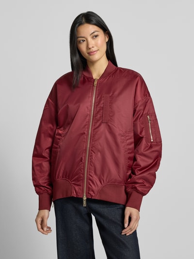 Vrouwenmodel draagt Relaxed Fit bomberjack met opstaande kraag Model 'Ruby' van MOS MOSH, rood, steekzakken, tweewegritssluiting, elastische boordjes, ruglengte maat S 56 cm, schouderbreedte 58 cm, borstwijdte 61 cm, mouwlengte 57 cm, Ganzkörperansicht van voren.