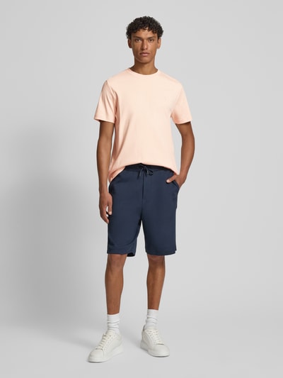 Männermodel trägt T-Shirt mit Logo-Stitching Modell 'Priamo' von JOOP! Collection in Hellrosa, Baumwolle, gerader Schnitt, Ganzkörperansicht von vorne