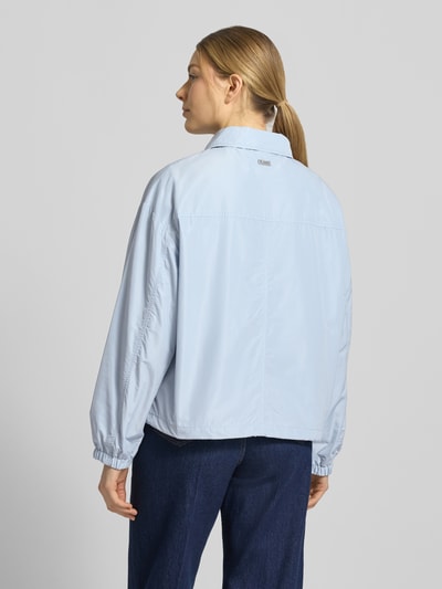 Frauenmodel trägt kurtka Jacke mit Pattentaschen Modell 'CICAMI' von CINQUE, krój regular fit, wykładany kołnierz, zamek błyskawiczny, kieszenie z patką, długość tyłu w rozmiarze 36: 58 cm, szerokość ramion w rozmiarze 36: 50 cm, szerokość klatki piersiowej w rozmiarze 36: 56 cm, długość rękawów w rozmiarze 36: 59 cm, jasnoniebieski kolor, gładka tekstura, widoczne szwy, Ganzkörperansicht Rückansicht.
