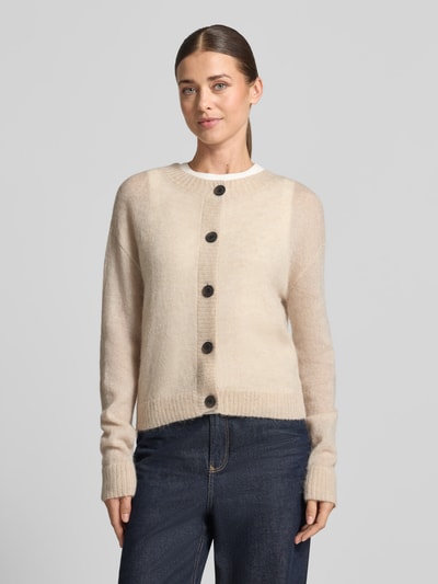 Frauenmodel trägt Strickjacke mit Woll-Anteil von COMMA in Beige, taillierte Passform, gerippte Abschlüsse, Ganzkörperansicht von vorne.