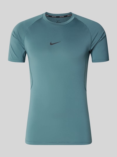 Produktfoto, T-Shirt mit Logo-Print und Rundhalsausschnitt von NIKE TRAINING in Blaugrün, Slim Fit, kurze Raglanärmel, glatte Textur