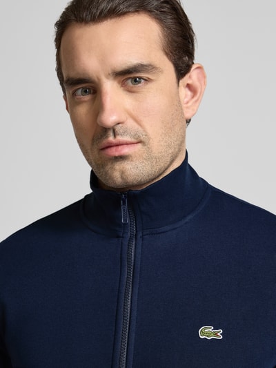 Männermodel trägt Regular Fit Sweatjacke aus Baumwoll-Mix von Lacoste in Optik: Unifarben, mit Logo-Patch, Nahaufnahme Oberkörper.