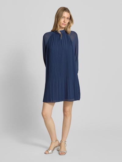 Frauenmodel trägt Minikleid mit Plisseefalten Modell 'Ingrid' von GUIDO MARIA KRETSCHMER WOMAN aus fließendem Stoff, Gerader-Schnitt, Stehkragen, dunkles Blau, Ganzkörperansicht von vorne. Rückenlänge 87 cm, Brustweite 48 cm, Ärmellänge 65 cm, Größe 36.