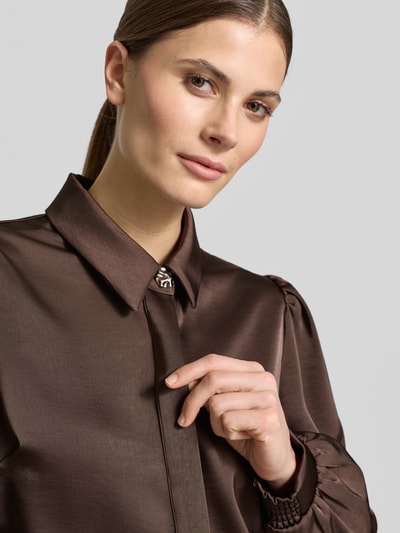 Modelka nosi Regular Fit Hemdbluse mit Raffungen Modell 'Fransala' od Neo Noir w brązie, marszczenia, ozdobne kamienie, elastyczny materiał, zbliżenie górnej części ciała.