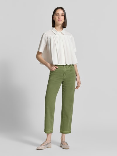 Frauenmodel trägt Feminine Fit Jeans mit Fransen und Eingrifftaschen von Marc Cain aus Baumwoll-Elasthan-Mix in Grün, Ganzkörperansicht von vorne. Bundweite bei Größe 36: 38 cm, Innenbeinlänge bei Größe 36: 70 cm.