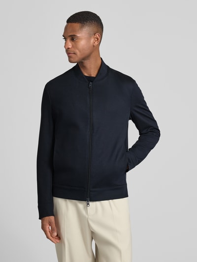 Męski model nosi Regular Fit Sweatjacke mit Viskose-Anteil Modell 'Cross' od CINQUE, granatowa, gładka struktura, widok całej sylwetki z przodu.