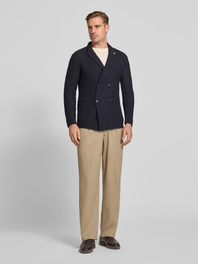 Männermodel trägt Slim Fit Sakko mit Reverskragen von Manuel Ritz in Dunkelblau, Reine Baumwolle, Zweireiher, AufgesetzteTaschen, Ganzkörperansicht von vorne. Rückenlänge 75 cm, Schulterbreite 40 cm, Ärmellänge 61 cm, Größe M.