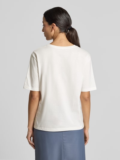 Frauenmodel trägt T-Shirt mit Motiv-Print von Marc Cain in Weiß, lockerer Schnitt aus reiner Baumwolle, Ganzkörperansicht Rückansicht.